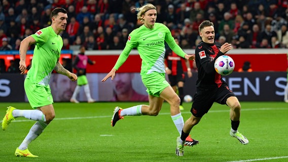 Leverkusens Florian Wirtz (v.r.) läuft den Wolfsburgern Sebastiaan Bornauw und Cedric Zesiger davon © IMAGO/Weis/TEAM2sportphoto 