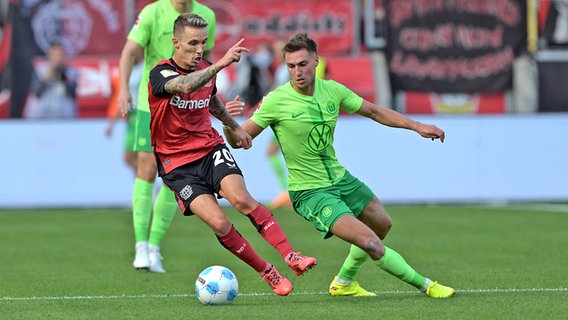 Kilian Fischer (r.) vom VfL Wolfsburg im Duell mit Alejandro Grimaldo von Bayer Leverkusen © picture alliance/dpa | Federico Gambarini 