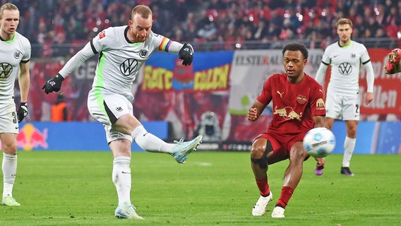 Maximilian Arnold (M.) vom VfL Wolfsburg im Duell mit RB Leipzig beim Abschluss © IMAGO / Jan Huebner 