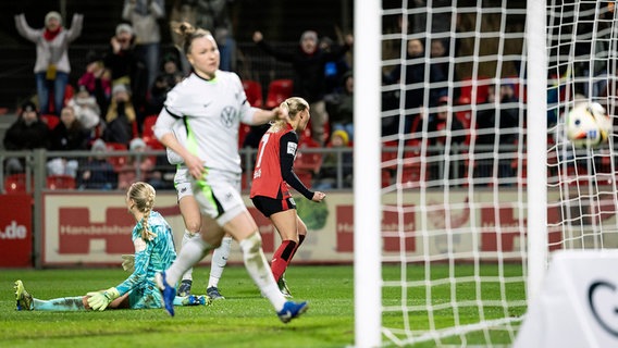 Die Wolfsburgerinnen Merle Frohms (l.) und Marina Hegering (Mitte) schauen einem Ball hinterher © IMAGO / Beautiful Sports 