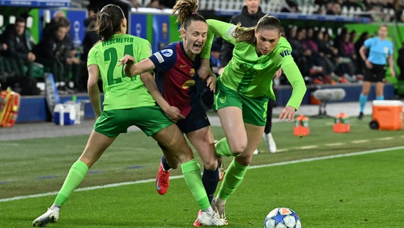 VfL Wolfsburg - FC Barcelona, K.o.-Runde, Viertelfinale, Hinspiele, Volkswagen Arena. Barcelonas Caroline Graham Hansen (M) in Aktion gegen Wolfsburgs Spielerinnen Joelle Wedemeyer (l) und Jule Brand. © picture alliance / dpa Foto: Swen Pförtner