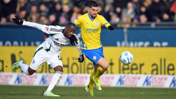 Braunschweigs Marvin Rittmuller (m.) spielt gegen Schalkes Ibrahima Cissé © picture alliance Foto: Swen Pförtner