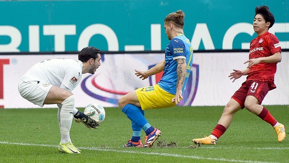 Braunschweigs Torhüter Marko Johansson, Teamkollege Kevin Ehlers und Kaiserslauterns Daisuke Yokota © IMAGO / Jan Huebner 