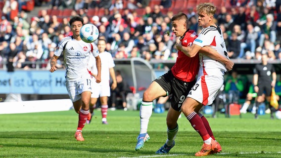 Hannovers Nicolo Tresoldi (l.) im Zweikampf mit Nürnbergs Nick Seidel © picture alliance Foto: Swen Pförtner