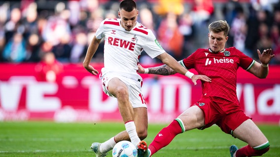 Hannovers Josh Knight (r.) und Kölns Tim Lemperle kämpfen um den Ball. © picture alliance/dpa | Marius Becker 