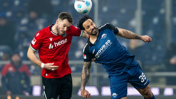 Hannovers Boris Tomiak (l.) und Paderborns Adriano Grimaldi kämpfen um den Ball. © picture alliance/dpa | David Inderlied 