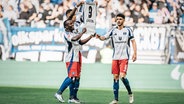 Die HSV-Spieler Jean-Luc Dompé, Davie Selke und Daniel Elfadli (v.l.) präsentieren nach einem Treffer ein Trikot vom verletzen Robert Glatzel in die Höhe. © IMAGO / Justus Stegemann 