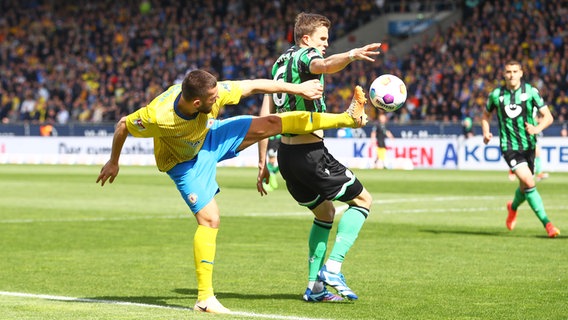 Braunschweigs Hasan Kurucay (l.) und Hannovers Fabian Kunze kämpfen um den Ball. © IMAGO / Jan Huebner 