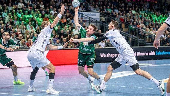 Kiels Hendrik Pekeler (l.) und Rune Dahmke versuchen Wetzlars Dominik Mappes beim Wurf zu stören. © IMAGO / Beautiful Sports 