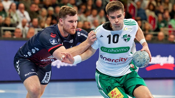 Johannes Golla (l., SG Flensburg-Handewitt) und Renars Uscins (TSV Hannover-Burgdorf) © IMAGO / eu-images 