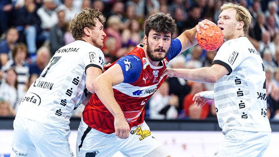 Magnus Landin (l.) und Eric Johansson (r.) vom THW Kiel im Duell mit Jacob Lassen vom Handball Sport Verein Hamburg © IMAGO / Eibner 