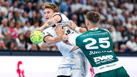 Emil Madsen (l.) vom THW Kiel im Duell mit Jurmala Astroem von FA Göppingen © IMAGO / Eibner 