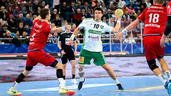 Renars Uscins (M.) von der TSV Hannover-Burgdorf im Spiel in Bietigheim. © imago images / Wolf-Sportfoto 