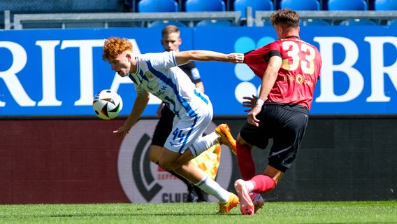 Hansa Rostocks Stürmer Tim Krohn behauptet den Ball gegen Wiesbadens Felix Luckeneder © IMAGO / Eibner 