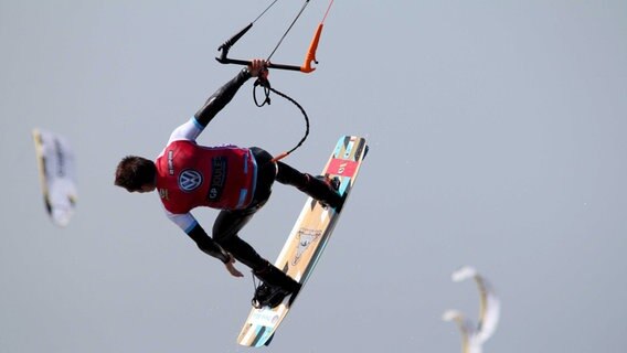 Ein Kitesurfer fliegt in St. Peter-Ording durch die Luft. © dpa-Bildfunk Foto: Wolfgang Runge