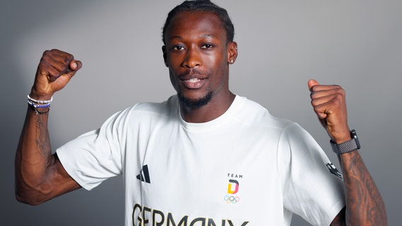 Sprinter Owen Ansah posiert im T-Shirt des deutschen Olympia-Teams © picture alliance / Team Deutschland 