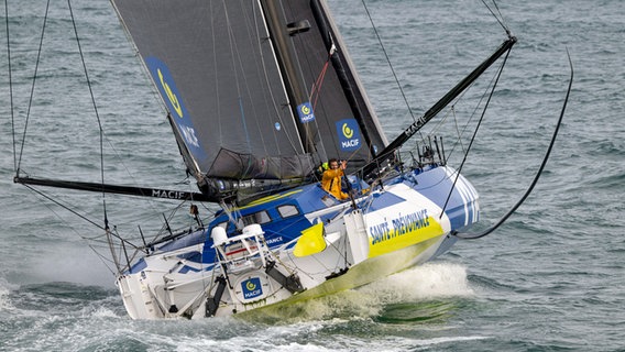 Charlie Dalin winkt kurz vor der bretonischen Küste von seiner Yacht Macif Santé Prévoyance. © Vendée Globe / Olivier Blanchet / Alea 