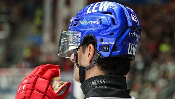 Ein Eishockey-Profi trägt einen schwarzen Halsschutz. © IMAGO / Beautiful Sports 