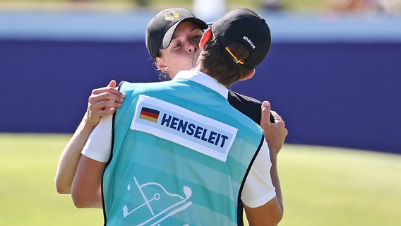 Die Hamburger Golferin Esther Henseleit küsst nach dem 18. Loch bei der Olympia-Schlussrunde ihren Coach und Freund Reece Phillips. © picture alliance/dpa | Jan Woitas 