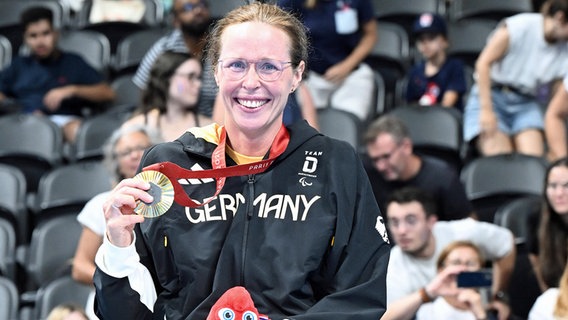 Tanja Scholz zeigt ihre Goldmedaille. © IMAGO / Ralf Kuckuck 