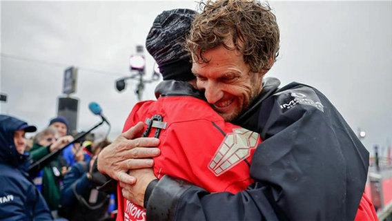 Jérémie Beyou (Charal) links und Paul Meilhat (Biotherm) umarmen sich im Hafen von Les Sables-d’Olonne. © Vendée Globe Foto: Anne Beauge / Alea