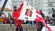 Boris Herrmann auf seiner Malizia in Les Sables-d'Olonne mit der Flagge des Yacht Club de Monaco © Olivier Blanchet / Alea 