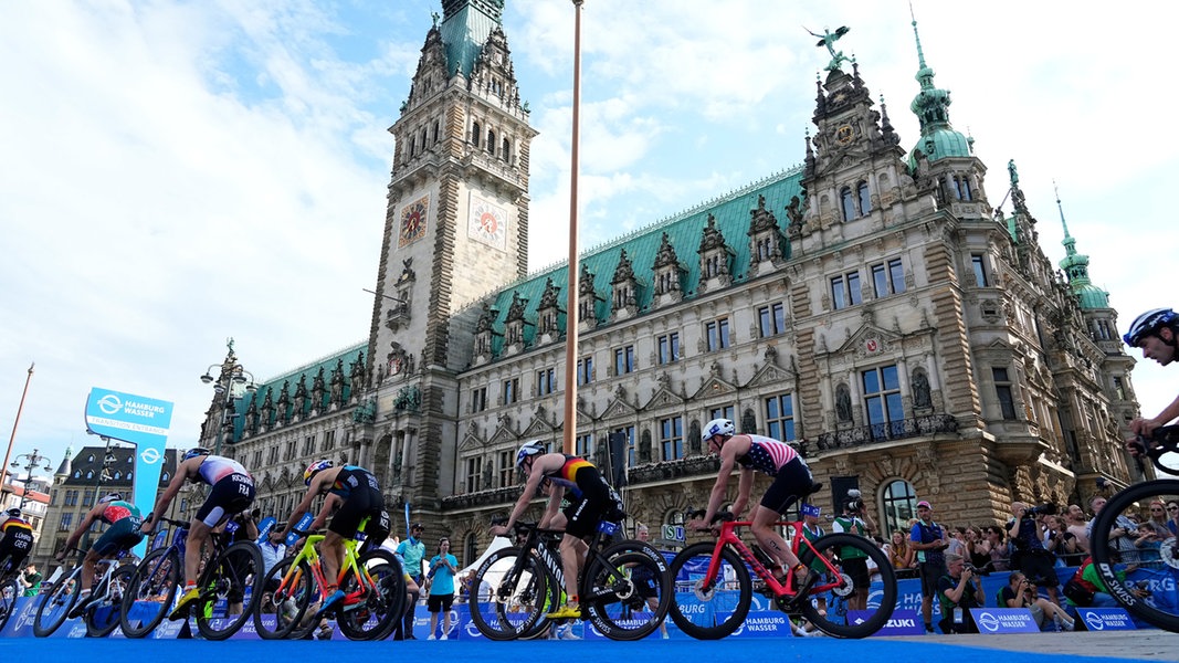 Triathleten auf dem Rad vor dem Hamburger Rathaus