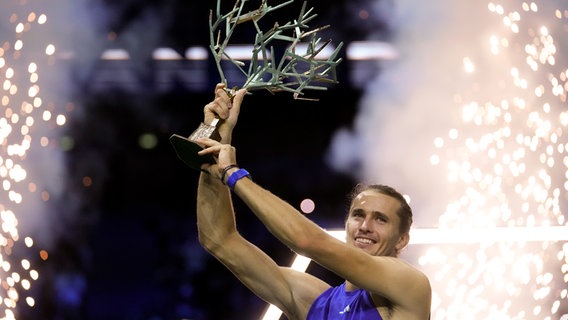 Der deutsche Tennisspieler Alexander Zverev präsentiert den Pokal nach dem Final-Sieg beim Paris Masters. © picture alliance/dpa/AP | Thibault Camus 