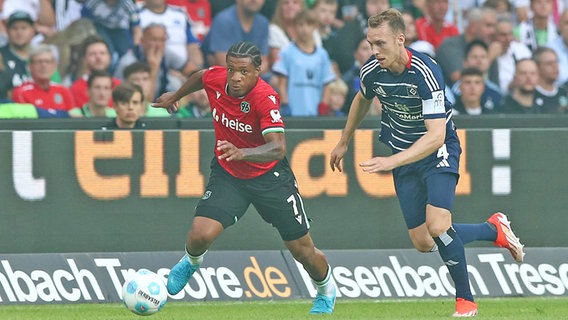 Jessic Ngankam (l.) von Hannover 96 im Duell mit Sebastian Schonlau vom Hamburger SV © IMAGO / Jan Huebner 