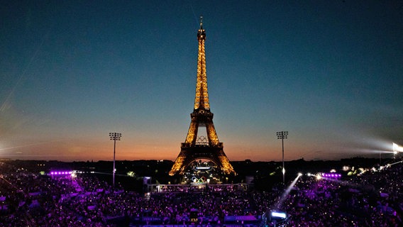 Der leuchtende Eiffelturm in Paris mit den olympischen Ringen. © IMAGO / Eibner 