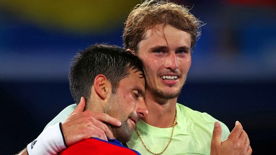 Der deutsche Tennis-Spieler Alexander Zverev (r.) jubelt üben den Einzug ins Finale, während der Serbe Novak Djokovic ihm im Arm liegend gratuliert. © dpa-Bildfunk Foto: Jan Woitas/dpa-Zentralbild/dpa