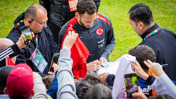 Ex-HSV-Profi Hakan Calhanoglu schreibt beim öffentlichen Training der türkischen Nationalmannschaft Autogramme © picture alliance/dpa | Moritz Frankenberg 