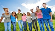 Eine Gruppe von Kindern steht in einem Halbkreis auf einer Wiese. © Colourbox Foto: Sergey Novikov