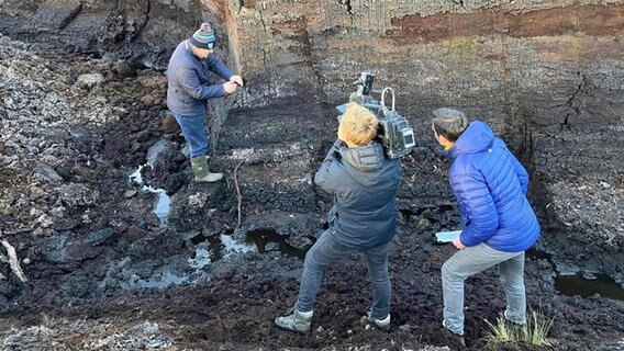 Eric Haasdonk an der Kamera, Sven Lohmann Report lassen sich in den Irischen Midlands von einem Iren die verschiedenen Torf-Schichten erklären. © NDR Foto: Johann Stoll