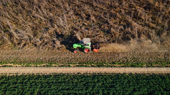 Ein Landwirt pflügt einen Acker mit einem Trecker. © picture alliance / greatif | greatif 