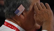 Trump Anhänger mit einem Patch der amerikanischen Flagge am Ohr auf dem Parteitag der Republikaner in  Milwaukee © AFP Foto: JIM WATSON