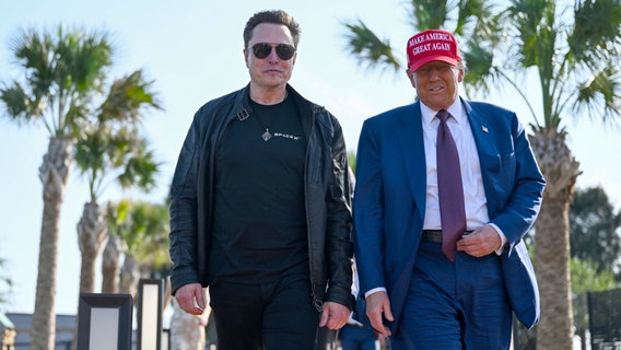 Donald Trump und Elon Musk gehen nebeneinander © picture alliance Foto: Brandon Bell