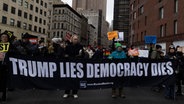 Demonstranten in New York tragen ein Banner mit der Aufschrift "Trump lies democracy dies" durch eine Straße. © Imago / ZUMA Press Wire Foto: Gina. M. Randazzo