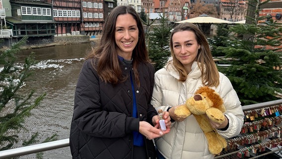 Die beiden Schwestern Nina und Michelle halten eine Flaschenpost und einen Stofftier-Löwen in die Kamera. Beide Gegenstände haben für sie eine wichtige Bedeutung © NDR Foto: Anina Pommerenke