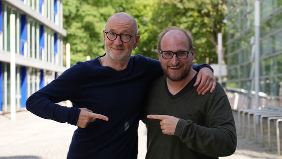 Peter Lohmeyer und Daniel Kaiser zeigen jeweils mit dem Finger auf den anderen. © NDR Foto: Frederike Burgdorf