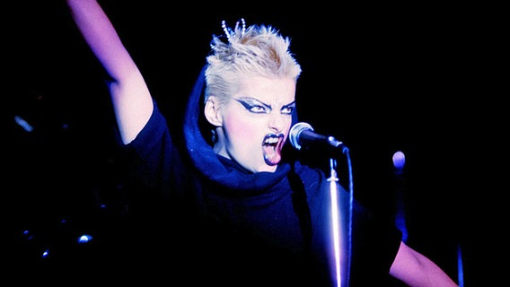 Nina Hagen in jungen Haaren mit blonder Kurzhaar-Frisur, sie reißt den Mund auf und schreit. Ihre Augen und Lippen sind schwarz geschminkt. © picture-alliance / Jazzarchiv Foto: Hardy Schiffler