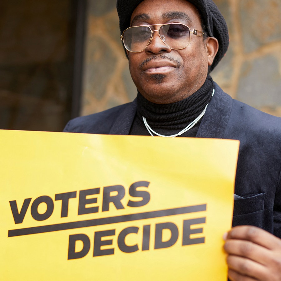 ein Wähler hält ein  gelbes Plakat hoch in Milwaukee, Wisconsin, USA © Reuters Foto: Daniel Steinle