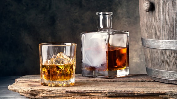 Ein Glas mit Whiskey neben einem Holzfass © fotolia Foto: alexlukin