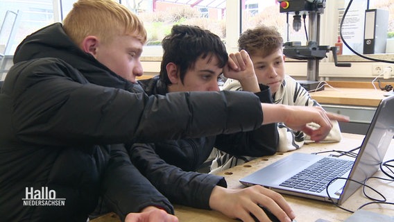 Schüler vor einem Laptop in einem Klassenraum. © Screenshot 
