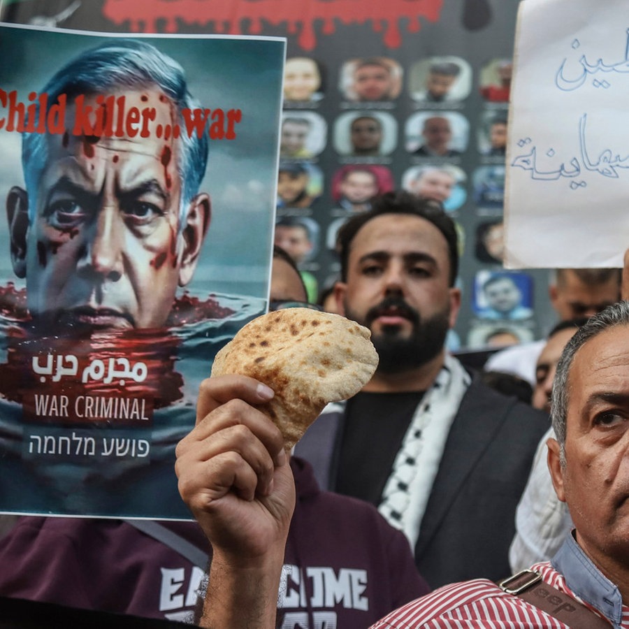 Ägyptische Aktivisten halten Brot und Plakate, unter anderem mit der Aufschrift «Es lebe Palästina, nieder mit den Uionistn», während sie an einer pro-palästinensischen Demonstration vor dem Gebäude des Journalisten-Syndikats teilnehmen. © Mohamed El Raai/AP/dpa 